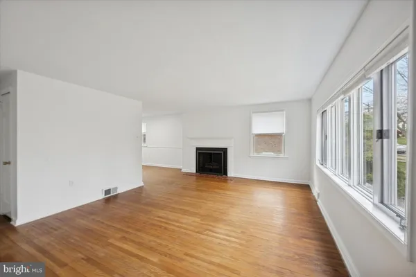 a view of a livingroom with wooden floor and a fireplace