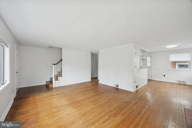 a view of empty room with wooden floor