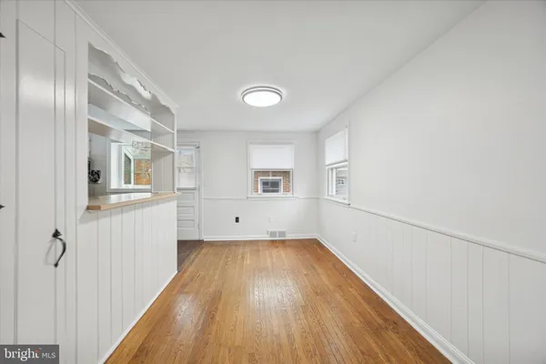 a view of a room with wooden floor and white walls