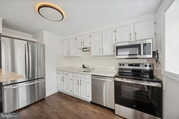 a kitchen with cabinets stainless steel appliances and a sink