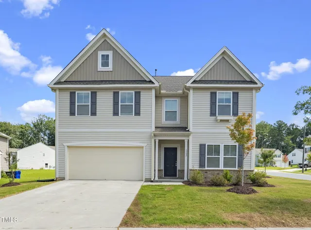 a front view of a house with a yard and garage