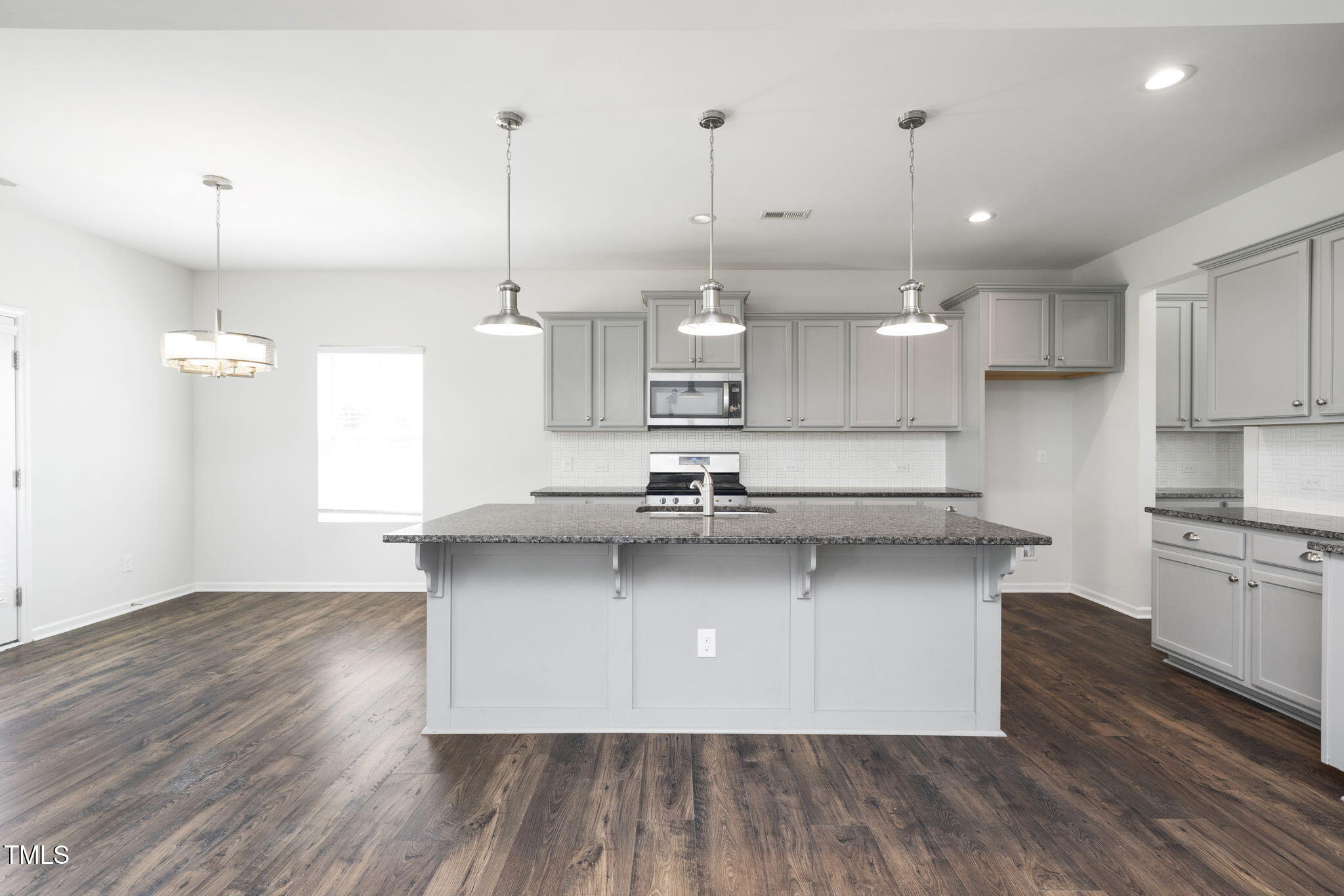 5502 Ripplebrook Drive Durham, NC 27712 - Photo 15 of 50 a kitchen with stainless steel appliances granite countertop a sink a stove a refrigerator and wooden floor