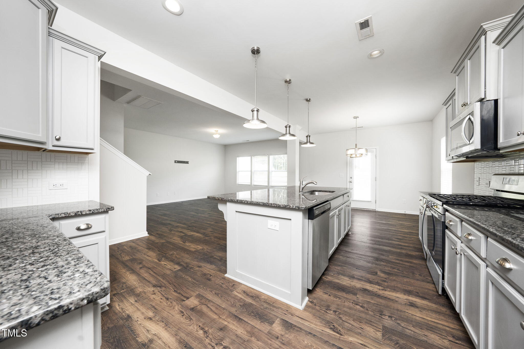 5502 Ripplebrook Drive Durham, NC 27712 - Photo 16 of 50 a kitchen with stainless steel appliances kitchen island granite countertop a stove and a sink