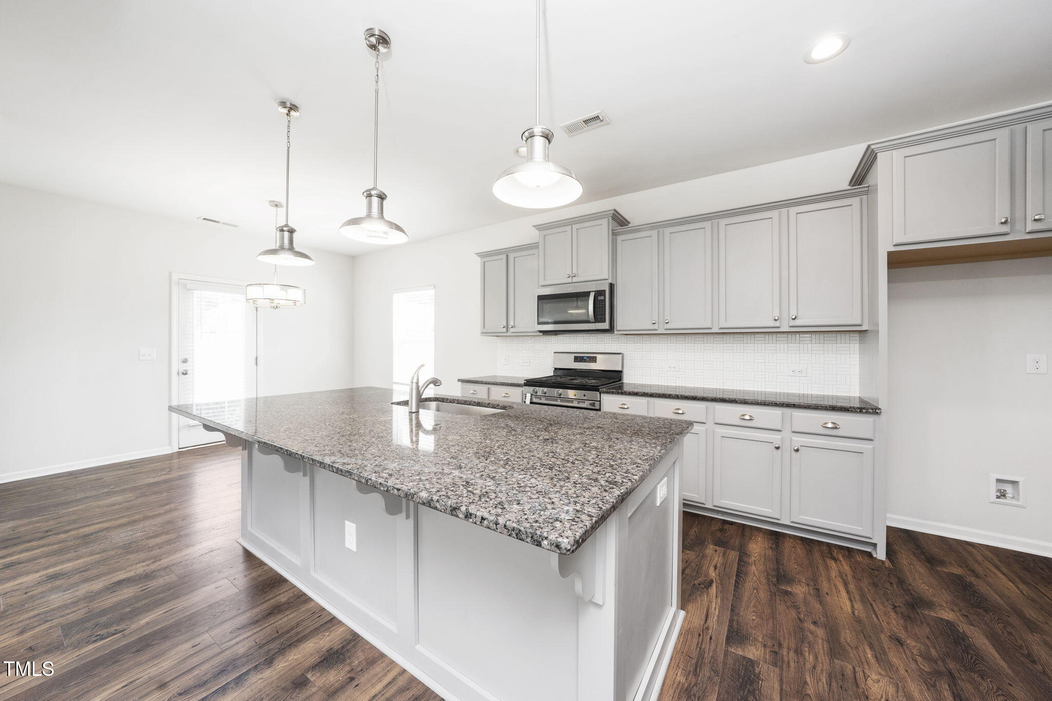 5502 Ripplebrook Drive Durham, NC 27712 - Photo 18 of 50 a kitchen with stainless steel appliances granite countertop a sink a stove and a wooden floors