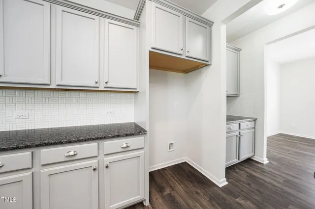 a kitchen with a sink cabinets and wooden floor