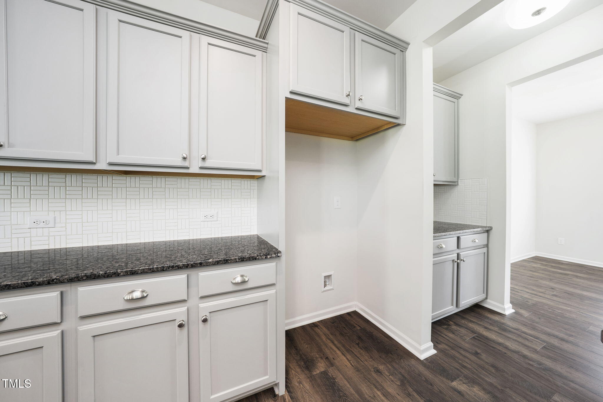 5502 Ripplebrook Drive Durham, NC 27712 - Photo 23 of 50 a kitchen with white cabinets and a wooden floor
