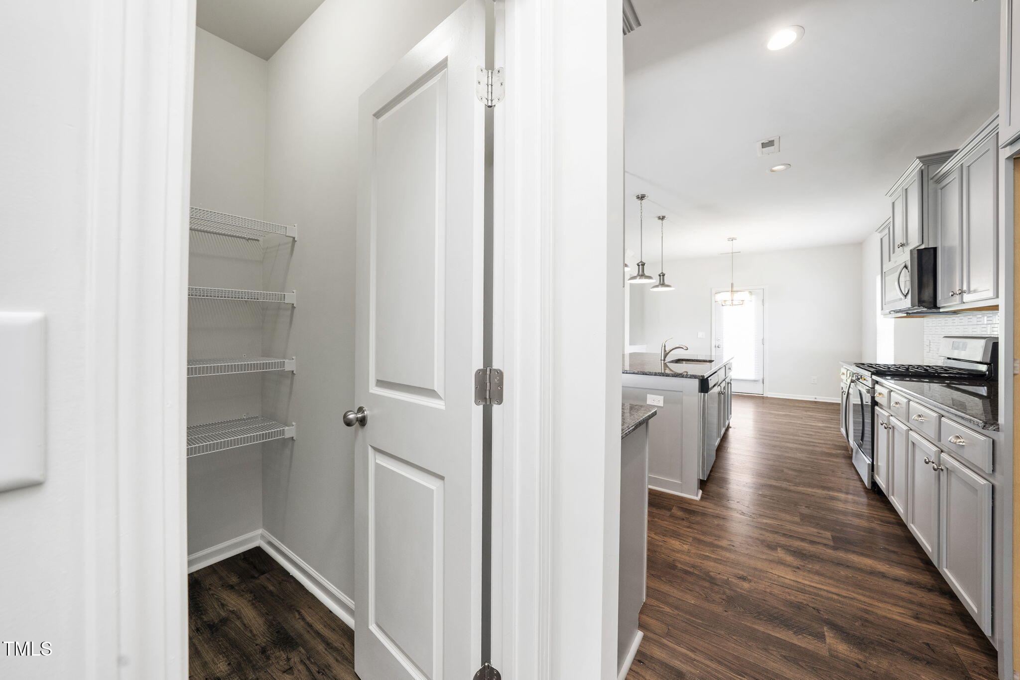 5502 Ripplebrook Drive Durham, NC 27712 - Photo 26 of 50 a kitchen with a refrigerator a stove top oven and wooden floor