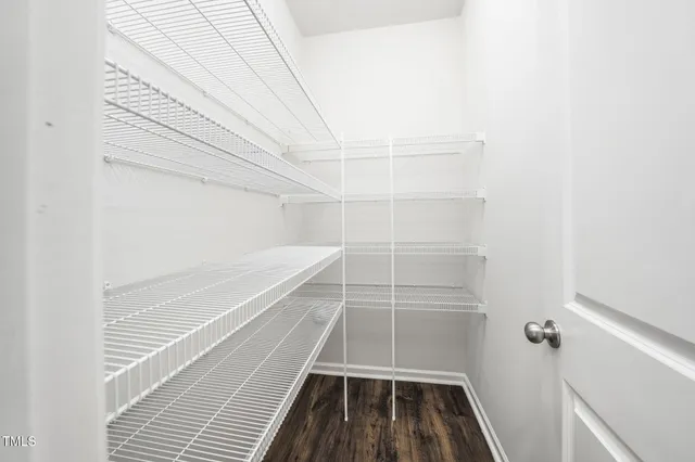 a kitchen with a refrigerator a stove top oven and wooden floor