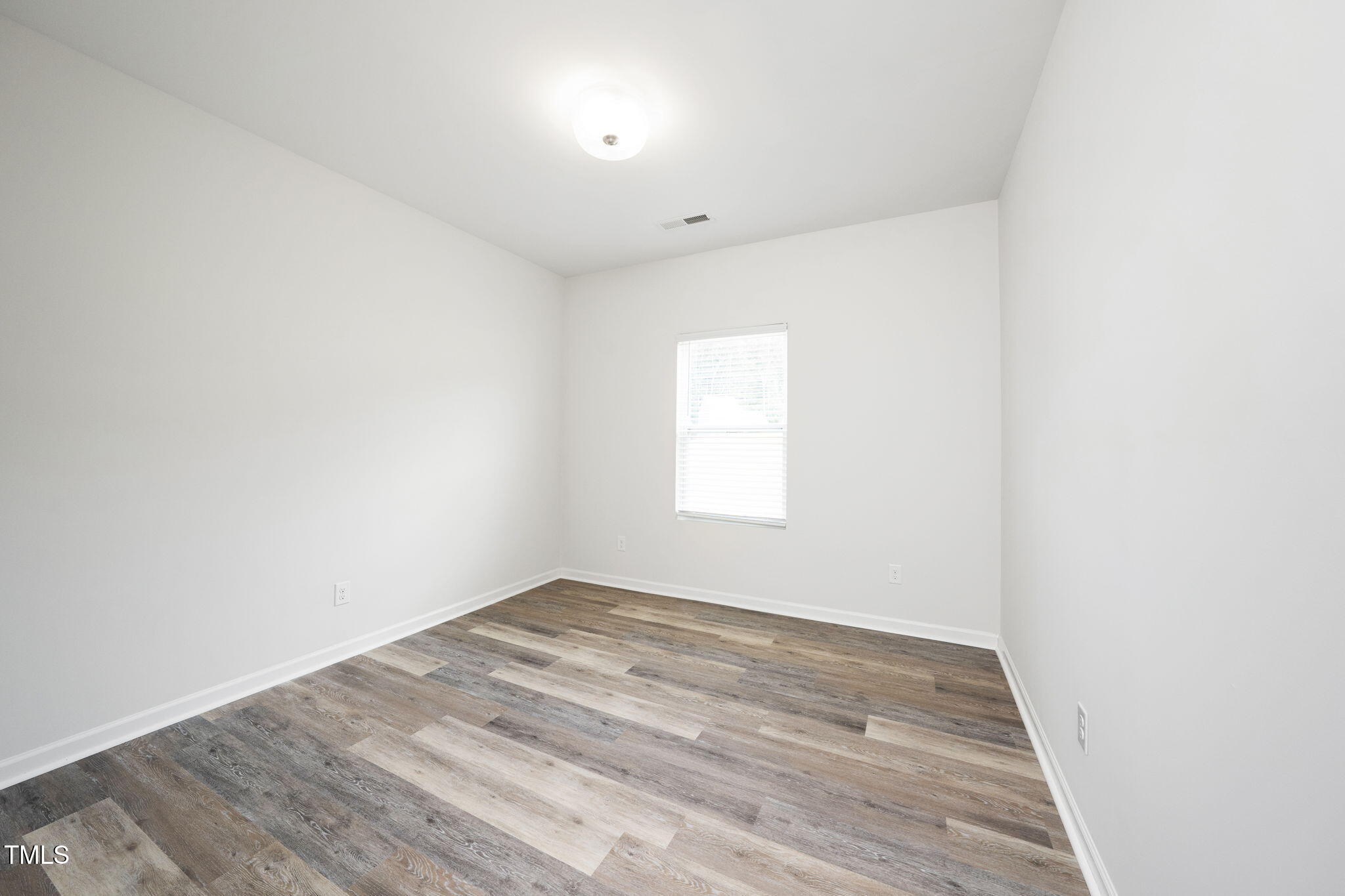 5502 Ripplebrook Drive Durham, NC 27712 - Photo 30 of 50 an empty room with wooden floor and windows