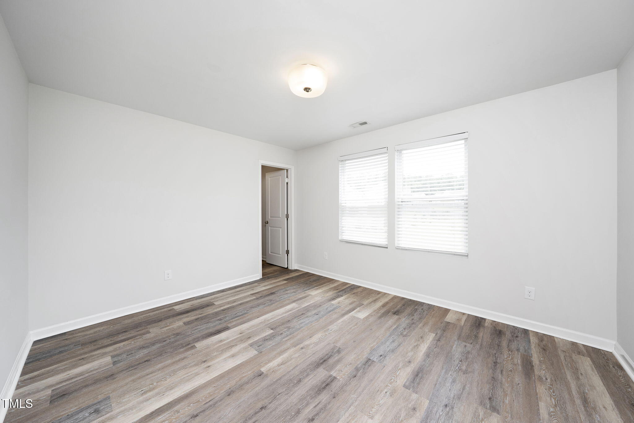 5502 Ripplebrook Drive Durham, NC 27712 - Photo 32 of 50 an empty room with wooden floor and windows
