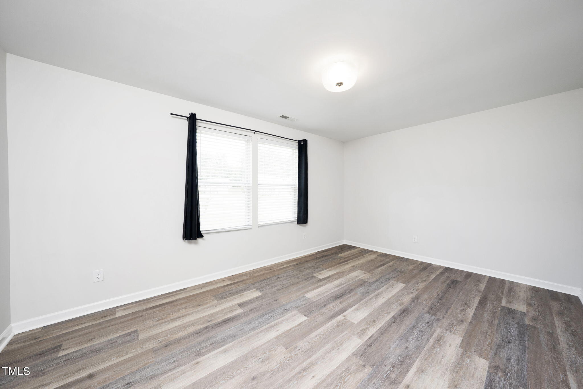 5502 Ripplebrook Drive Durham, NC 27712 - Photo 35 of 50 an empty room with wooden floor and windows