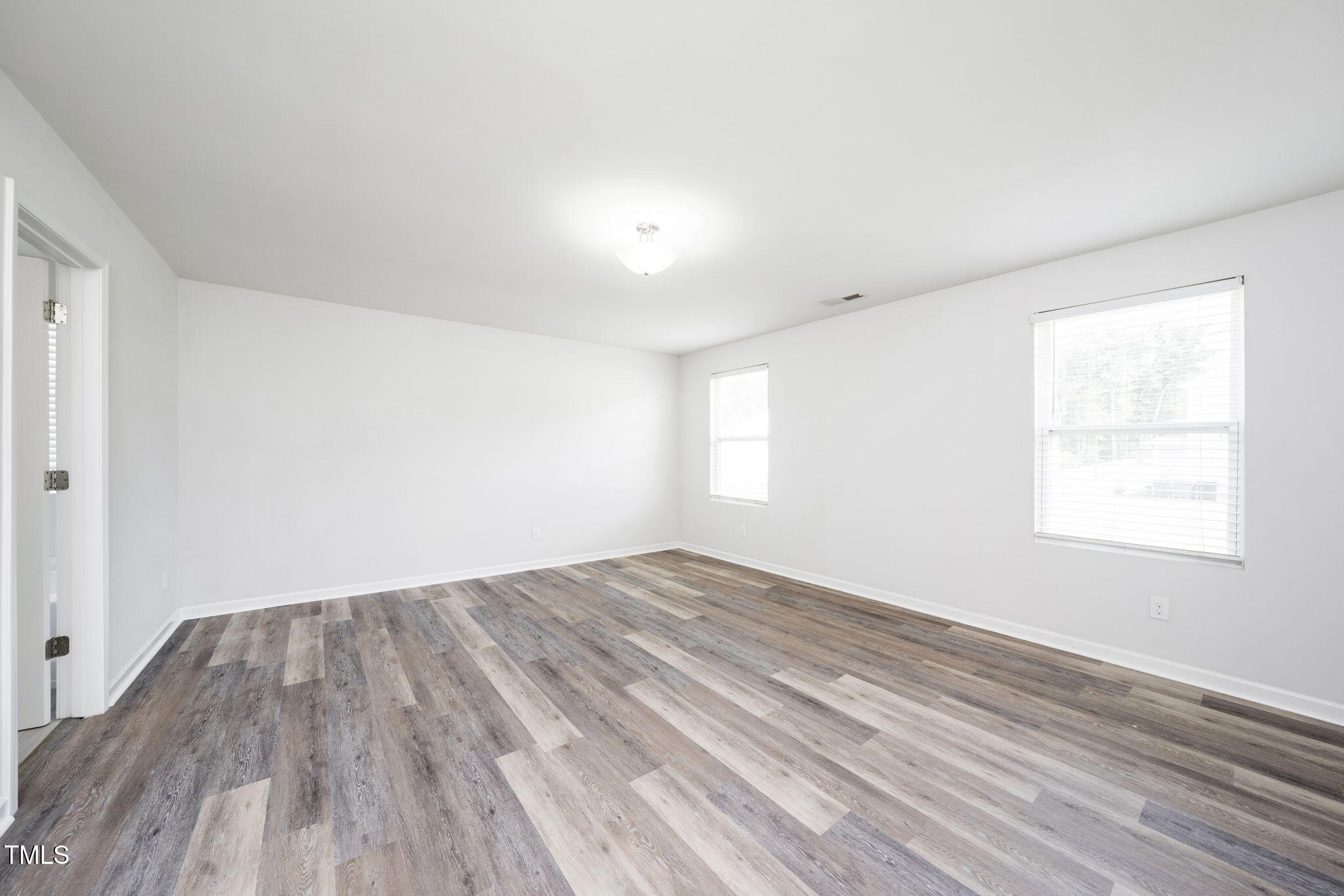 5502 Ripplebrook Drive Durham, NC 27712 - Photo 38 of 50 an empty room with wooden floor and windows