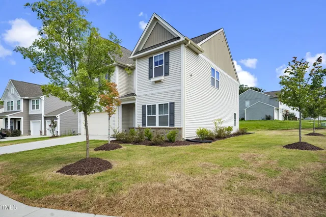 a front view of a house with a yard and trees