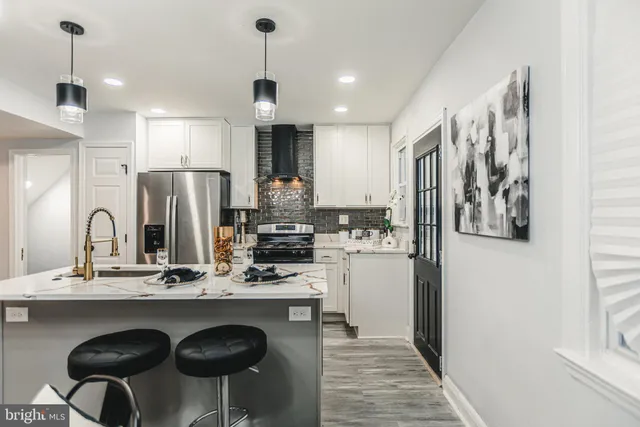 a kitchen with stainless steel appliances kitchen island granite countertop a refrigerator and a stove top oven