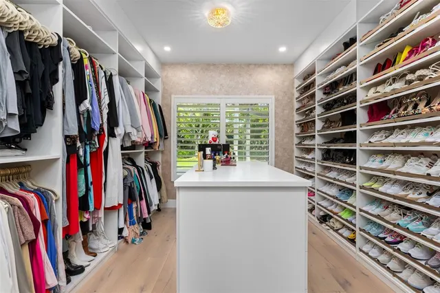 a view of walk in closet with clothes and shoes
