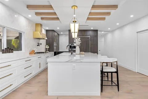 a large kitchen with kitchen island a large counter space a sink appliances and cabinets