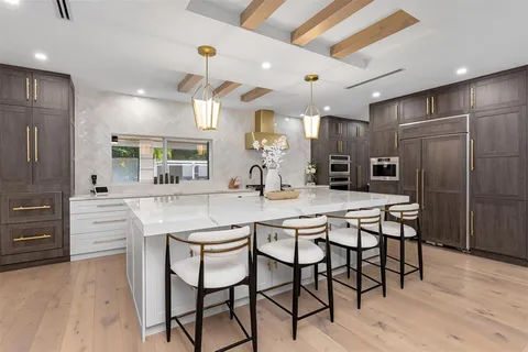 a kitchen with stainless steel appliances a stove a microwave and a potted plant