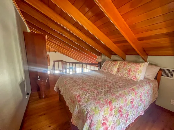 a bed sitting in a bedroom next to a larger window