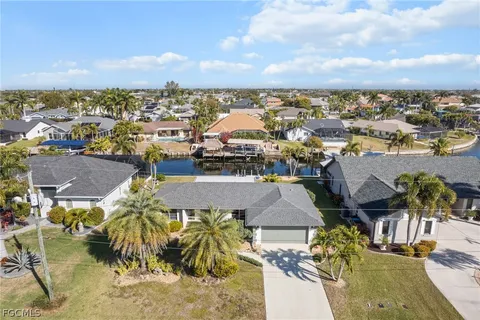 a view of a house with a yard and palm trees