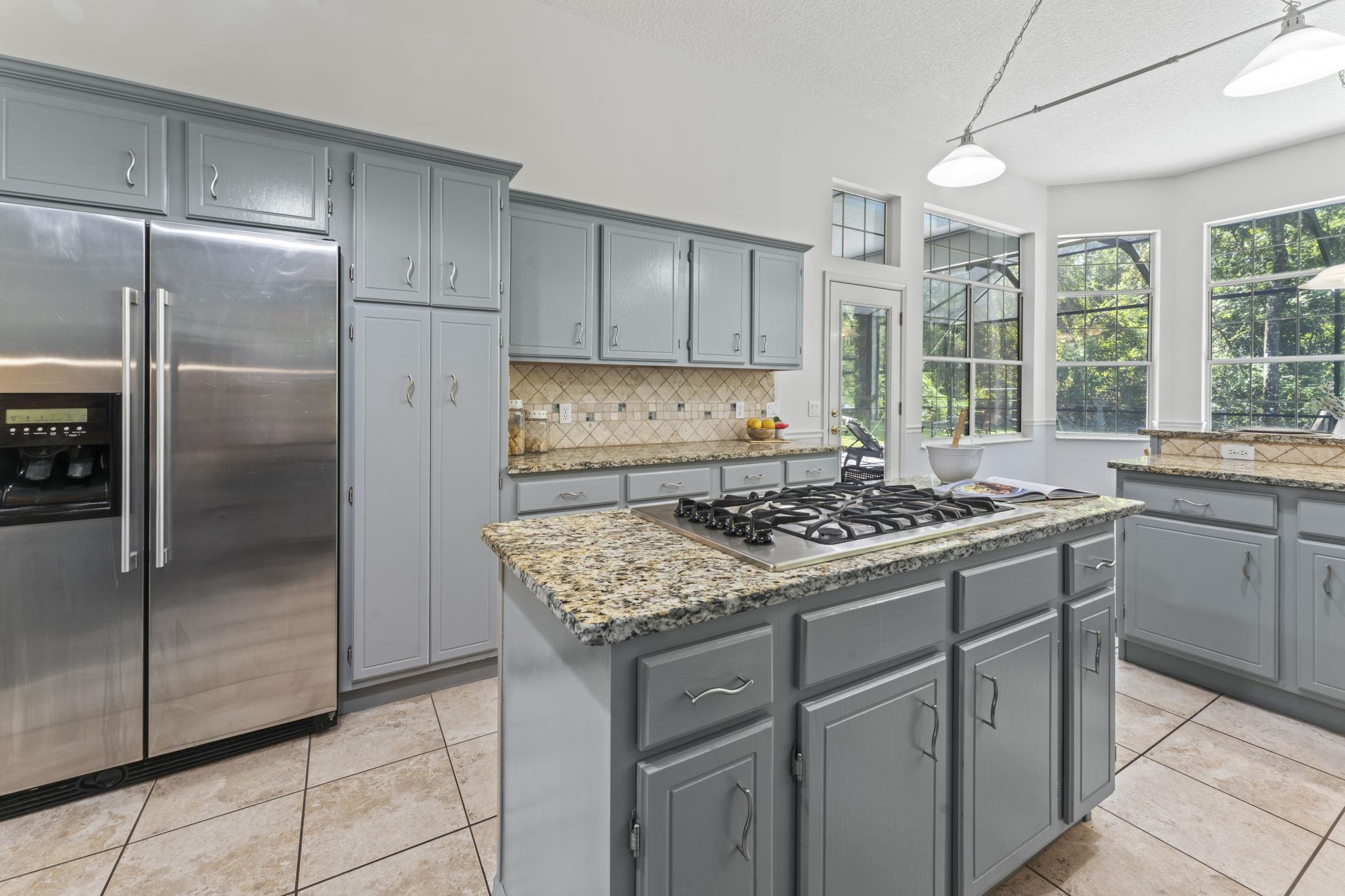 795 Kings Estate Road St. Augustine, FL 32086 - Photo 17 of 90 a kitchen with a stove a sink dishwasher a refrigerator and wooden cabinets