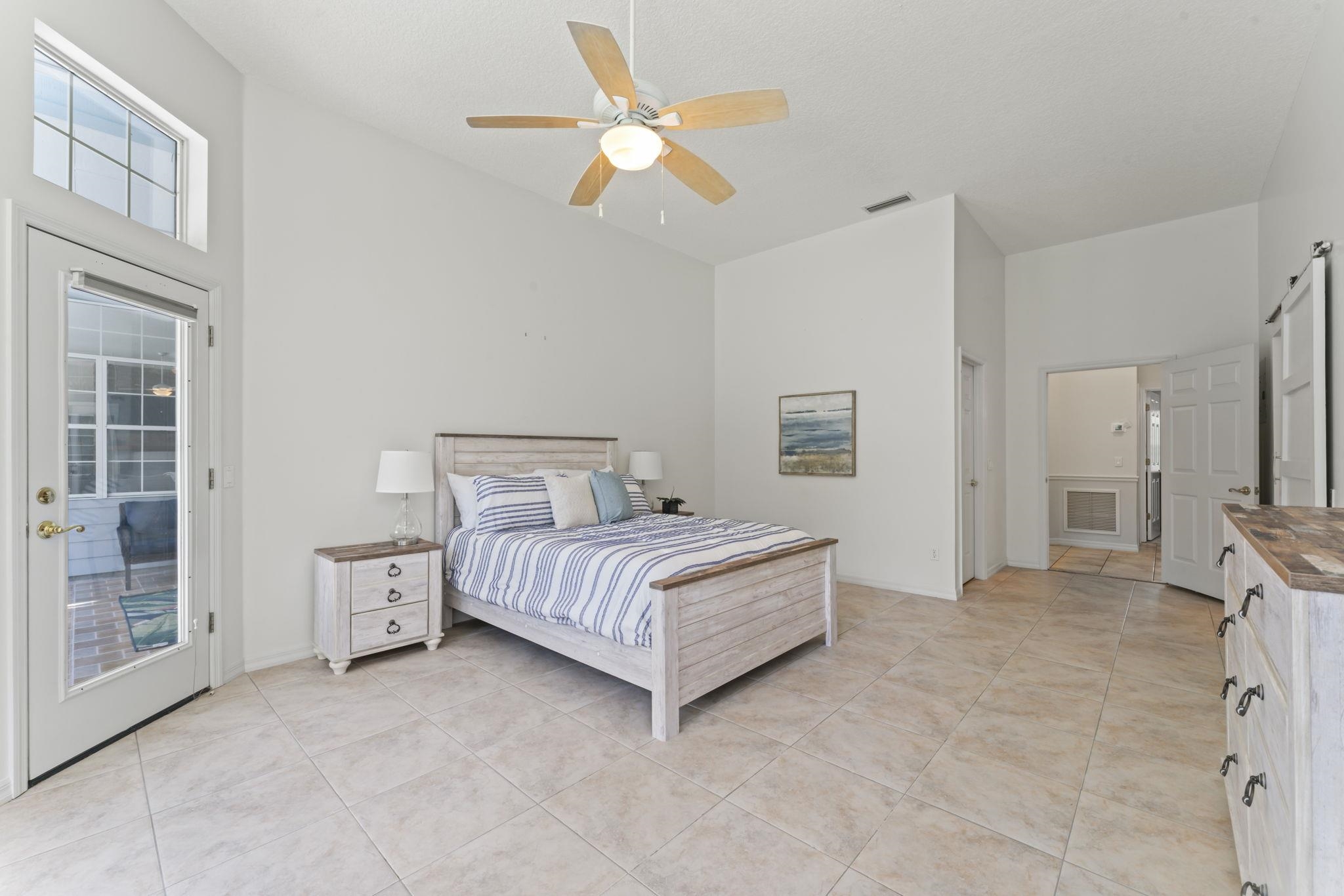 795 Kings Estate Road St. Augustine, FL 32086 - Photo 38 of 90 a spacious bedroom with a bed and a chandelier