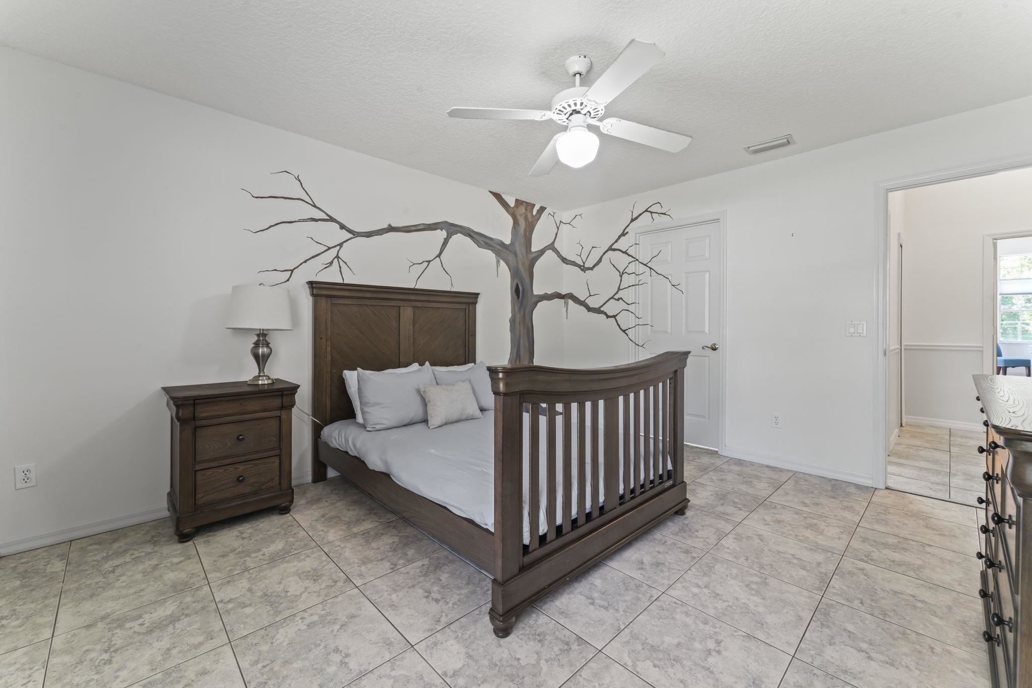 795 Kings Estate Road St. Augustine, FL 32086 - Photo 47 of 90 a bedroom with a bed and a chandelier