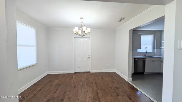 an empty room with wooden floor and sink