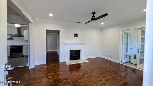 an empty room with fireplace and wooden floor