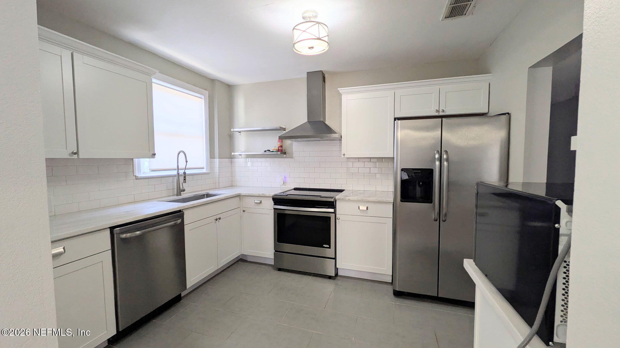 1218 Dancy Street Jacksonville, FL 32205 - Photo 6 of 19 a kitchen with stainless steel appliances a refrigerator sink and white cabinets