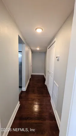 a view of a hallway with wooden floor