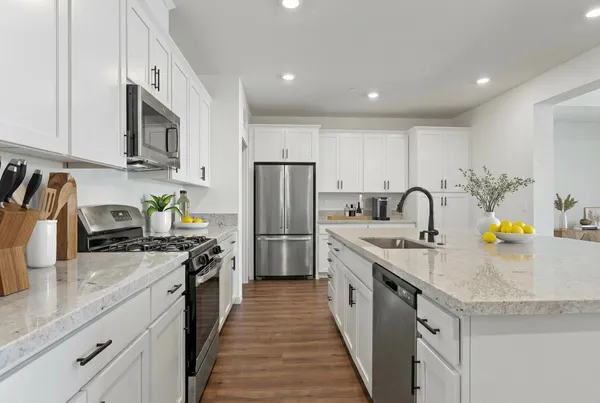 a kitchen with stainless steel appliances granite countertop a sink stove and refrigerator