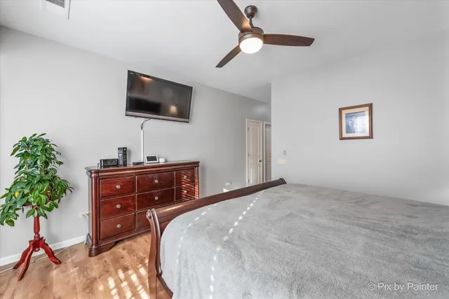 a bedroom with a bed and a flat tv screen on dresser