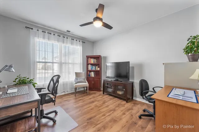 a view of a workspace with furniture and a window