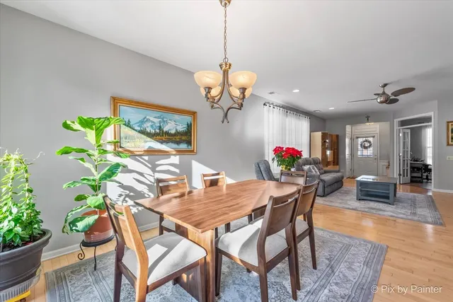 a dining room filled chandelier and wooden floor