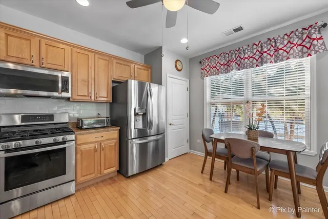 a kitchen with granite countertop wooden floors appliances and furniture