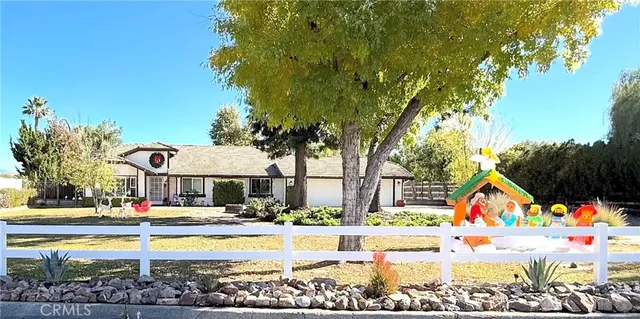 a view of large trees and a yard in front of it
