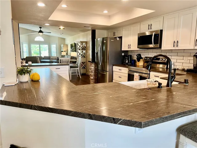 a kitchen with granite countertop a refrigerator stove and oven