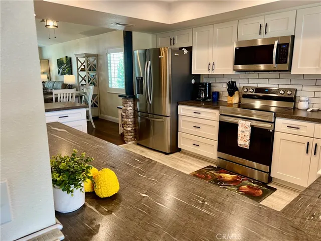 a kitchen with stainless steel appliances granite countertop a stove and a microwave