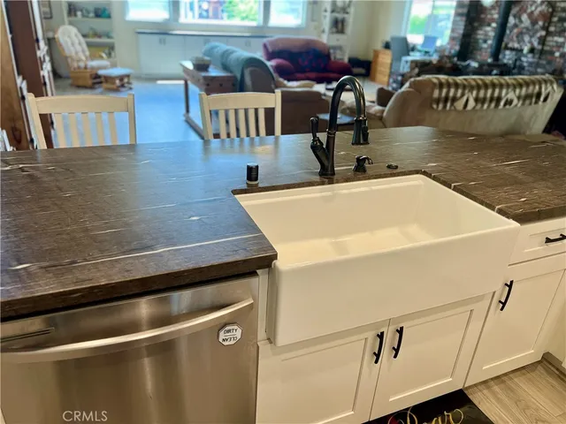 a view of a patio with table and chairs potted plants with wooden floor and fence