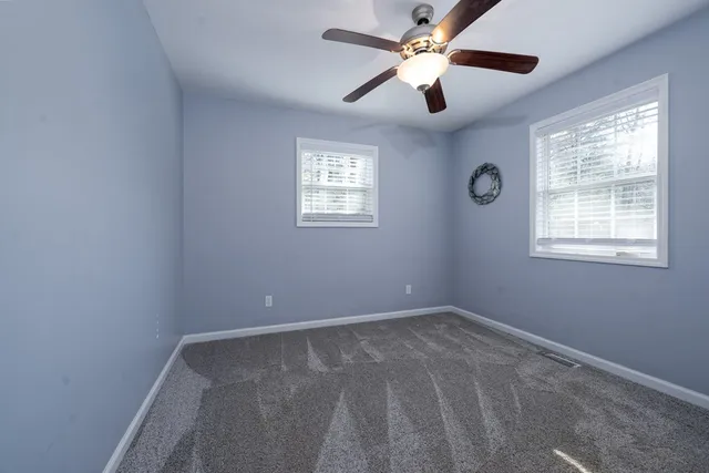 a bedroom with a bed chandelier and a window