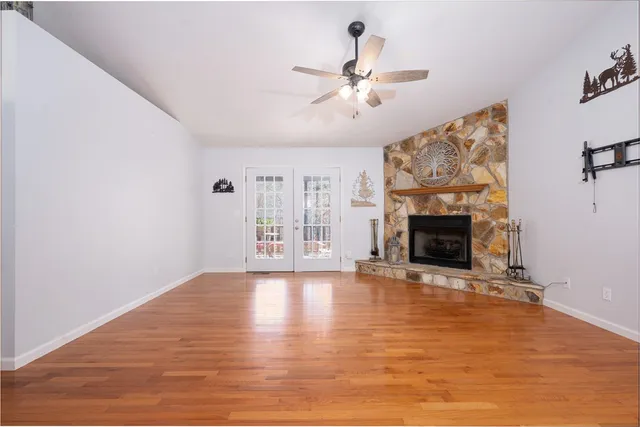 a view of empty room with fireplace and wooden floor