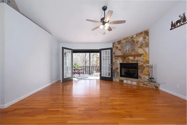 a view of an empty room with a fireplace and wooden floor