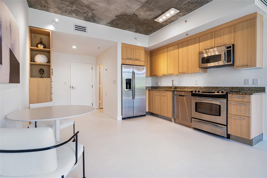 2001 Meridian Avenue, Unit 318 Miami Beach, FL 33139 - Photo 13 of 37 a kitchen with stainless steel appliances a stove a sink and a microwave