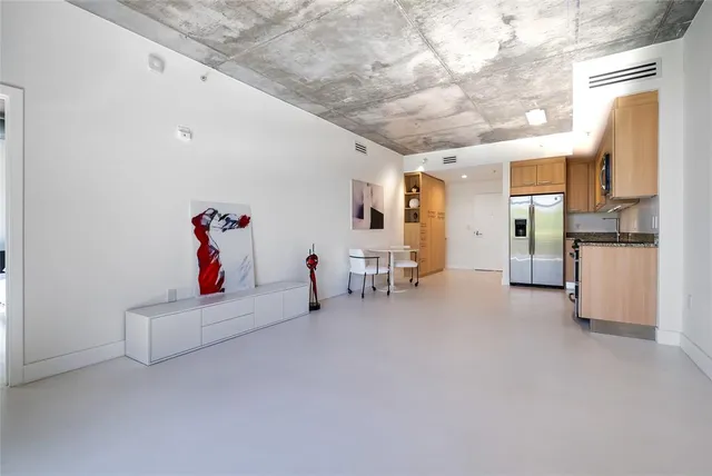 a kitchen with stainless steel appliances granite countertop white cabinets a microwave a sink and a refrigerator