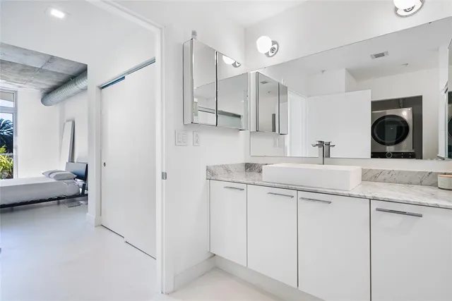 a bathroom with a granite countertop sink a toilet and shower