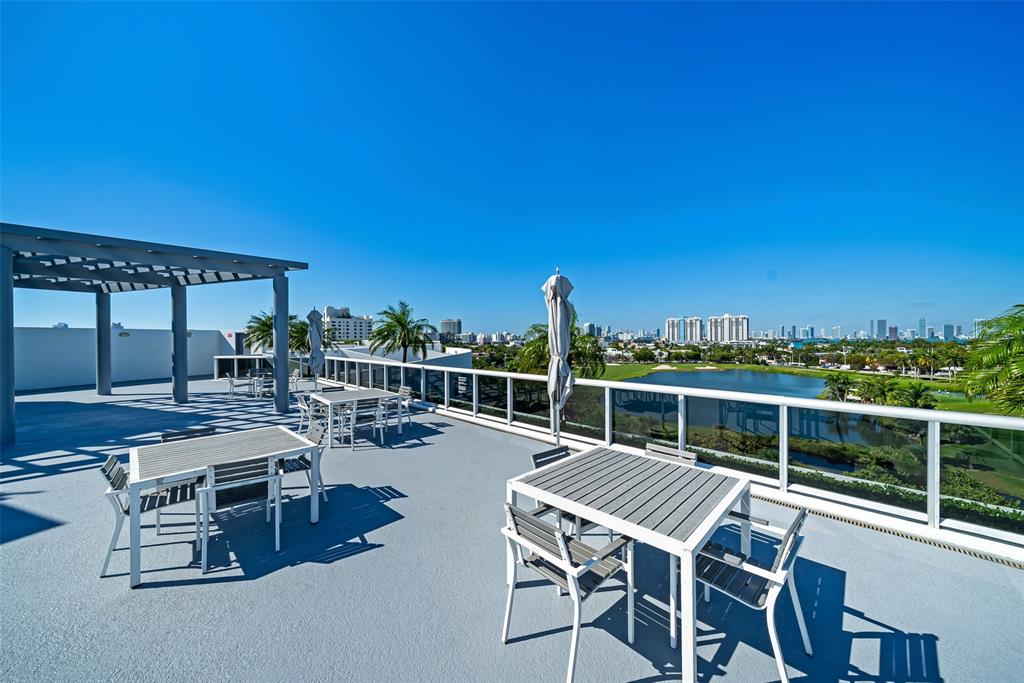 2001 Meridian Avenue, Unit 318 Miami Beach, FL 33139 - Photo 30 of 37 a roof deck with table and chairs a barbeque