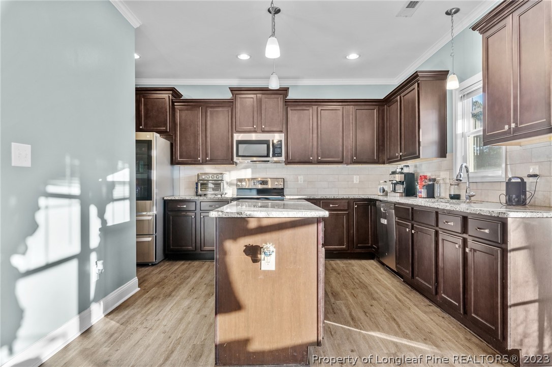 108 Roy's Ridge Raeford, NC 28376 - Photo 11 of 32 a kitchen with kitchen island granite countertop wooden cabinets stainless steel appliances a sink and a center island
