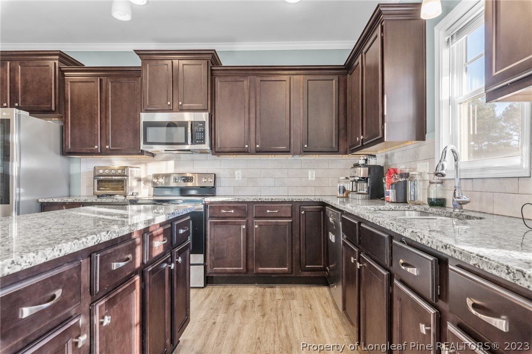 108 Roy's Ridge Raeford, NC 28376 - Photo 12 of 32 a kitchen with stainless steel appliances granite countertop a sink stove microwave and cabinets