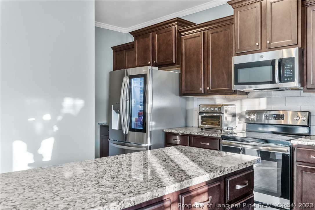108 Roy's Ridge Raeford, NC 28376 - Photo 14 of 32 a kitchen with stainless steel appliances granite countertop a stove refrigerator and microwave
