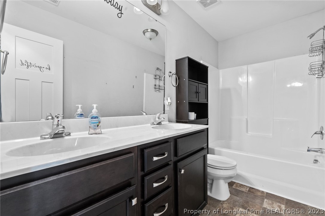 108 Roy's Ridge Raeford, NC 28376 - Photo 25 of 32 a bathroom with a granite countertop toilet sink and mirror